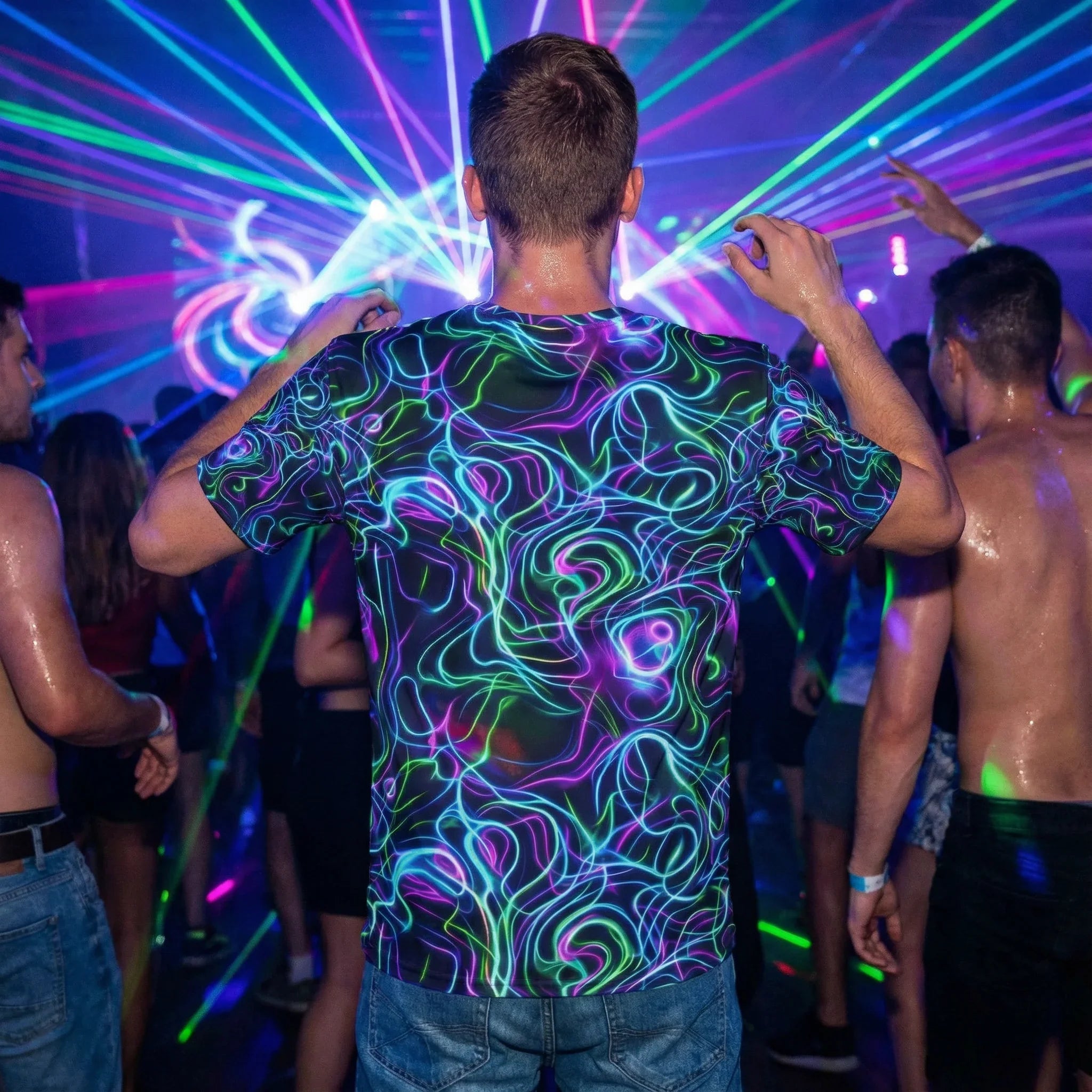 Person wearing neon psychedelic t-shirt dancing at vibrant laser-lit party with crowd