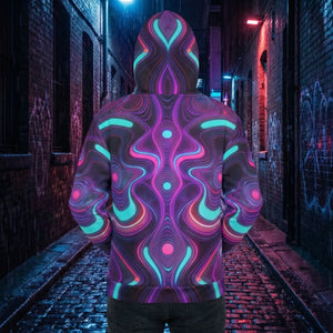 Person wearing a neon psychedelic hoodie with vibrant abstract patterns in a moody urban alley.