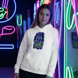 Woman wearing white hoodie with neon psychedelic face art print posing by colorful neon lights