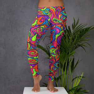 Close-up of a person wearing vibrant psychedelic all-over print leggings with neon colors and abstract swirls, standing barefoot on a white platform