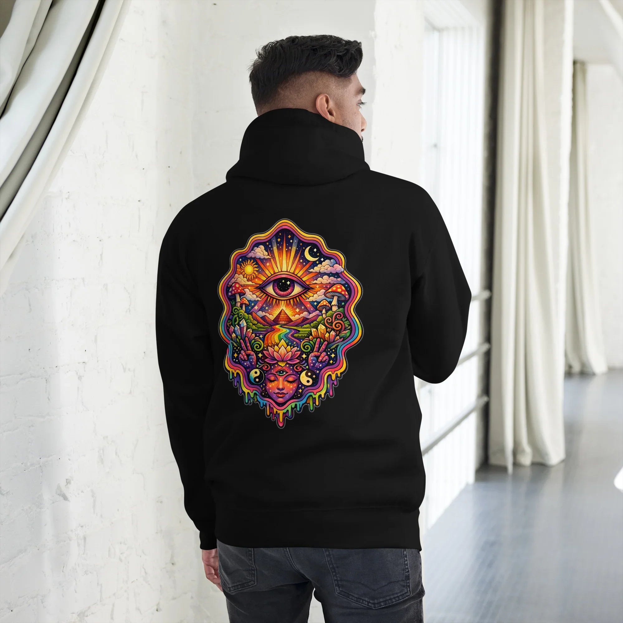 Man wearing black pullover hoodie with vibrant psychedelic colorful eye and nature design on back