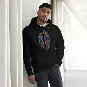 Man wearing black premium pullover hoodie with colorful psychedelic face art standing indoors