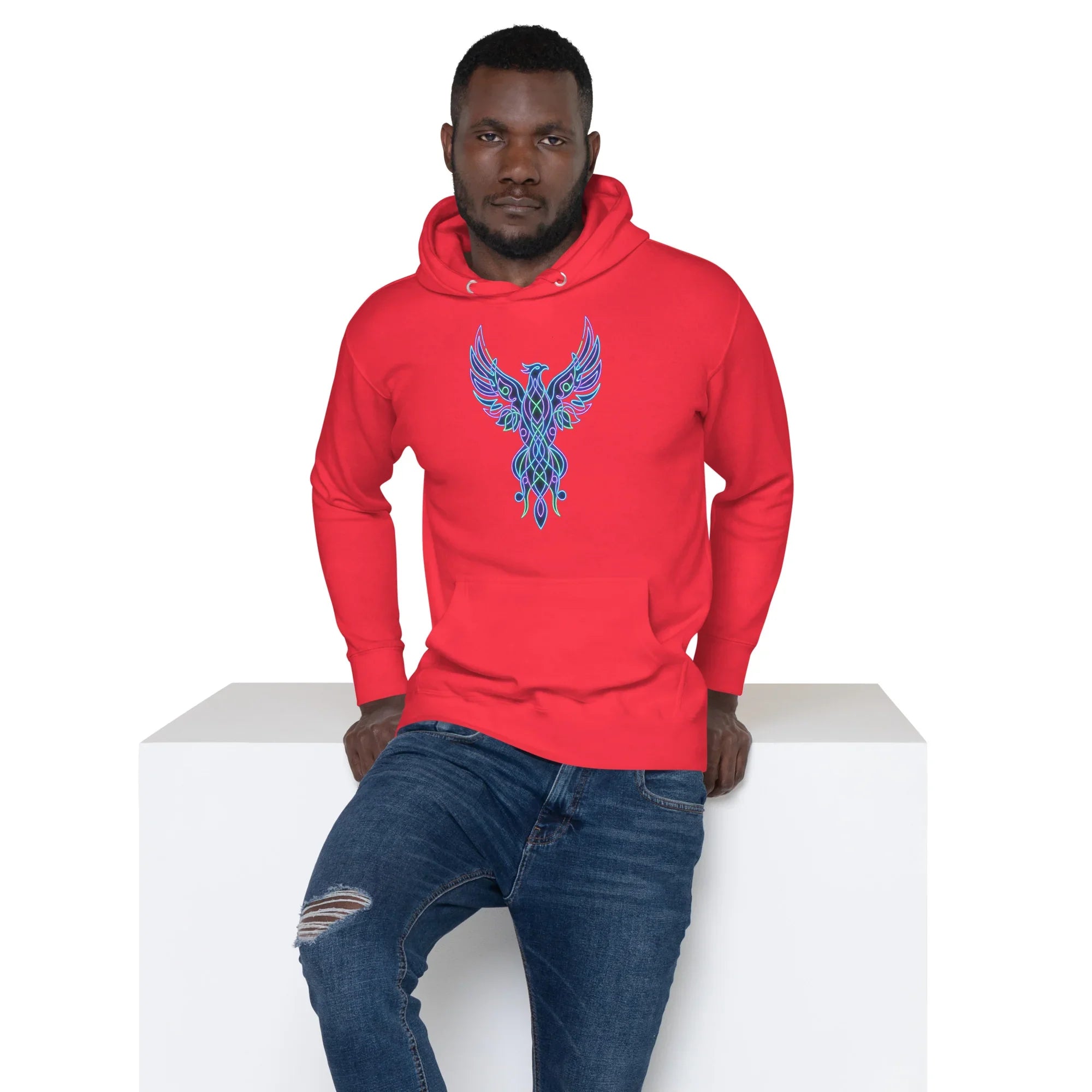 Man wearing a red unisex premium pullover hoodie with a neon blue and green phoenix design, paired with ripped blue jeans