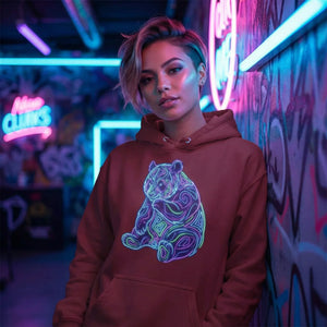 Person wearing red hoodie with neon psychedelic bear design in vibrant graffiti room with blue and pink neon lights