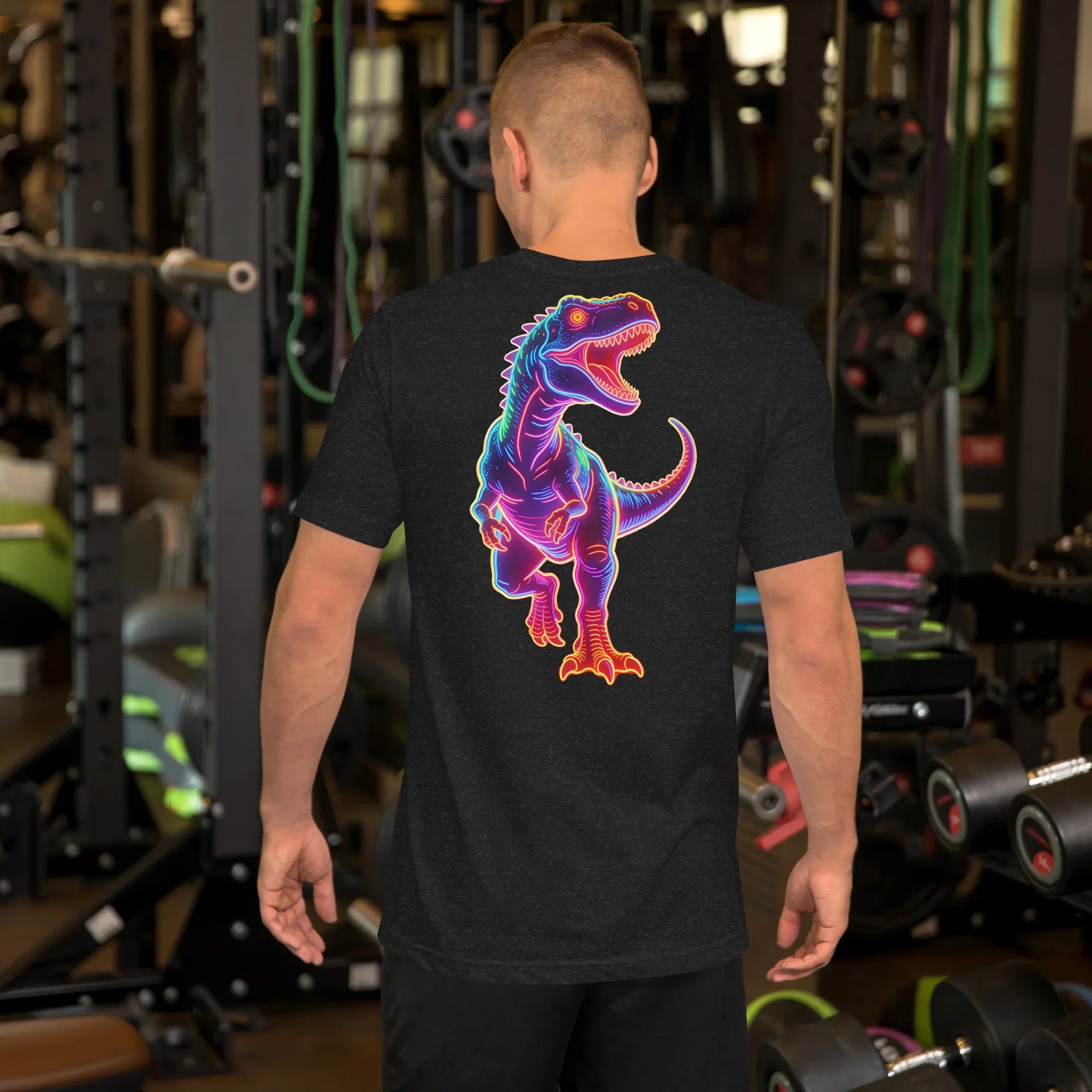 Man wearing black heather t-shirt with neon blue and pink roaring T-Rex design in gym setting
