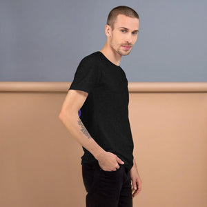 Model wearing black heather unisex staple t-shirt with short sleeves against beige and gray backdrop