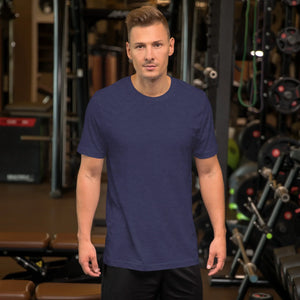 Man wearing a heather midnight navy unisex staple t-shirt standing in a gym with fitness equipment