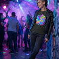Young woman in leather jacket and neon psychedelic t-shirt leaning against graffiti wall in vibrant nightclub