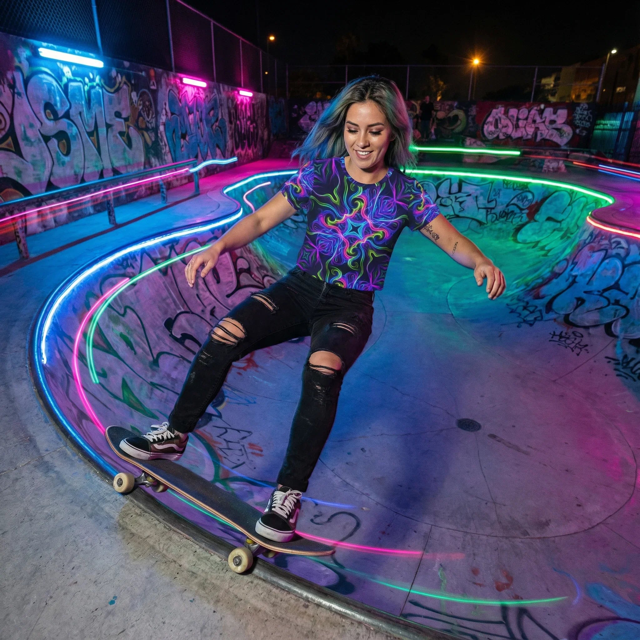Young woman skateboarding at night in graffiti-covered skate park wearing vibrant psychedelic neon shirt