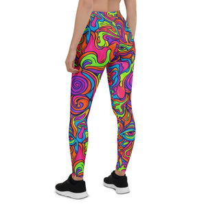 Back view of woman wearing high-waisted psychedelic leggings with vibrant neon swirl and mushroom patterns