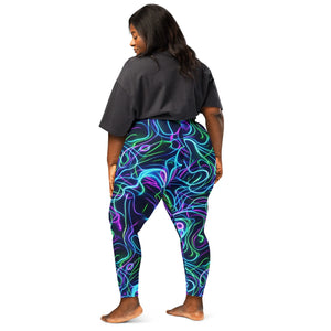 Curvy woman wearing psychedelic neon swirl printed leggings and a black oversized t-shirt, barefoot