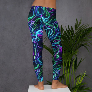 Person wearing black leggings with vibrant neon psychedelic swirl patterns against gray wall and green plants