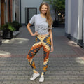Woman wearing colorful geometric print leggings and a grey t-shirt, standing on a city street.