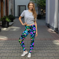 Woman wearing neon psychedelic print leggings and gray T-shirt, standing outdoors on a brick walkway