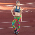 Woman in vibrant psychedelic print leggings and sports bra on running track, Mad Lad Designs