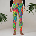Colorful psychedelic neon print leggings by Mad Lad Designs, modeled indoors with palm leaves