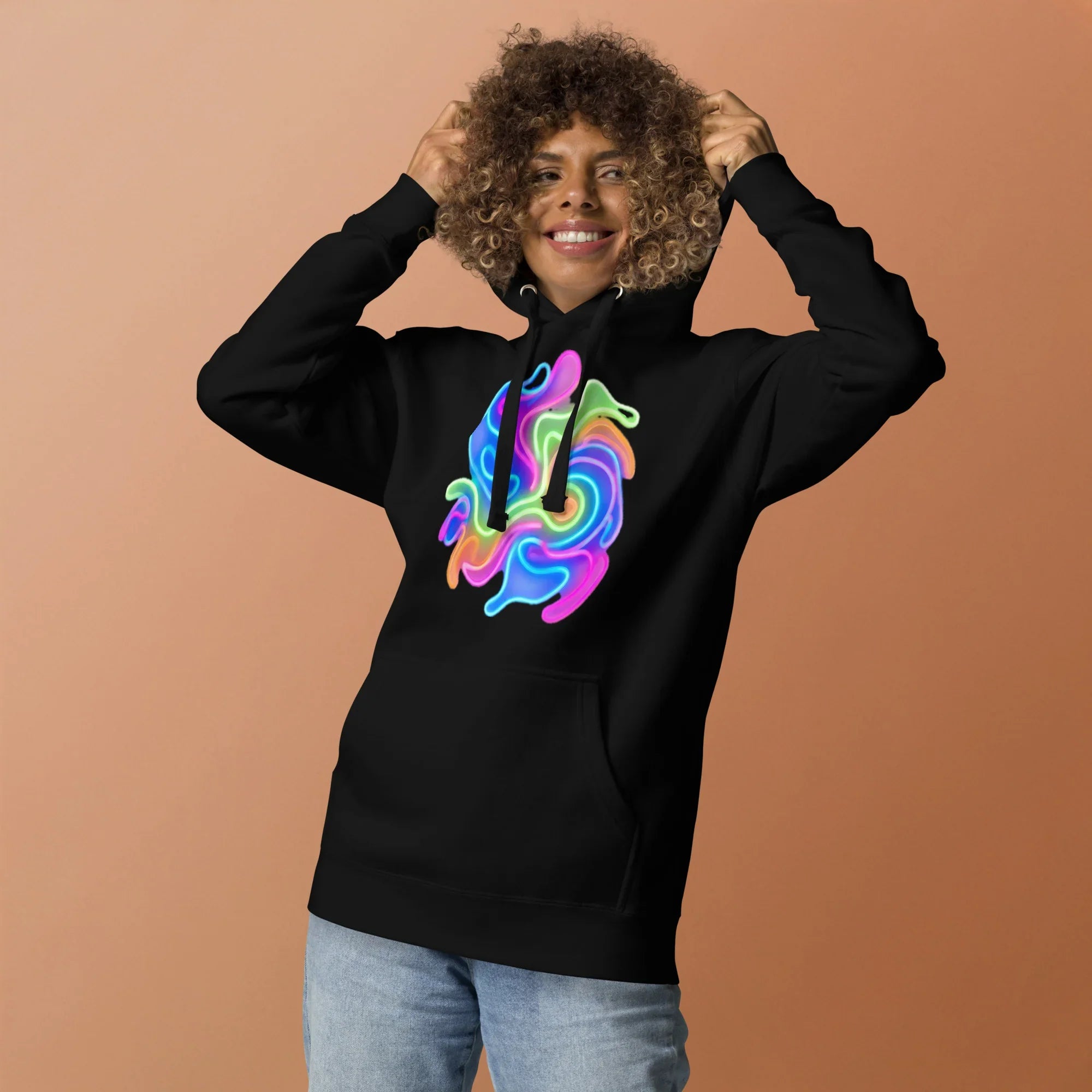 Smiling person wearing black unisex hoodie with bright neon psychedelic swirl design on front