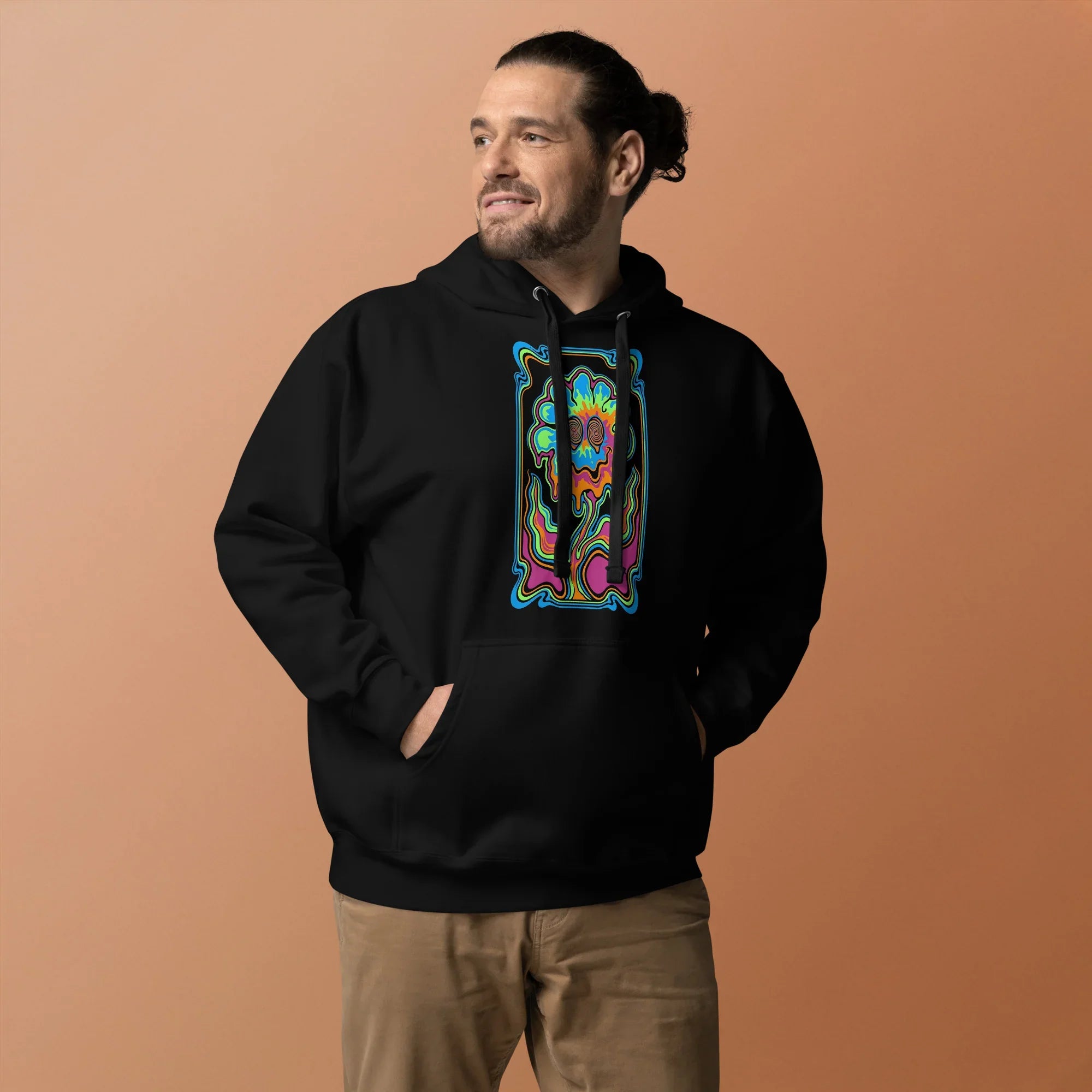 Man wearing black unisex premium pullover hoodie with psychedelic neon skull design on front