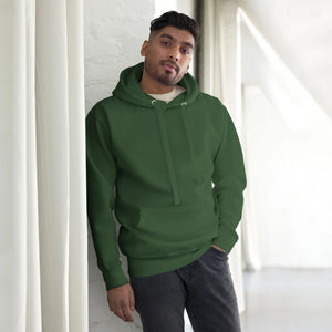Man wearing forest green unisex premium pullover hoodie with kangaroo pocket in bright indoor setting