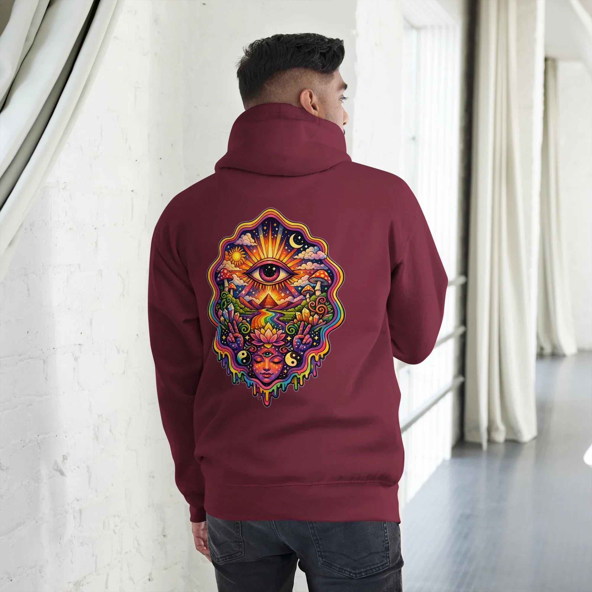Maroon unisex premium pullover hoodie with vibrant psychedelic eye and lotus design on back, worn by man indoors