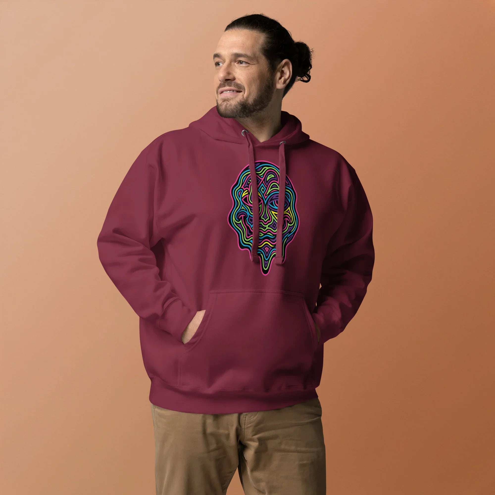 Man wearing maroon unisex premium pullover hoodie with colorful psychedelic face design and front pocket
