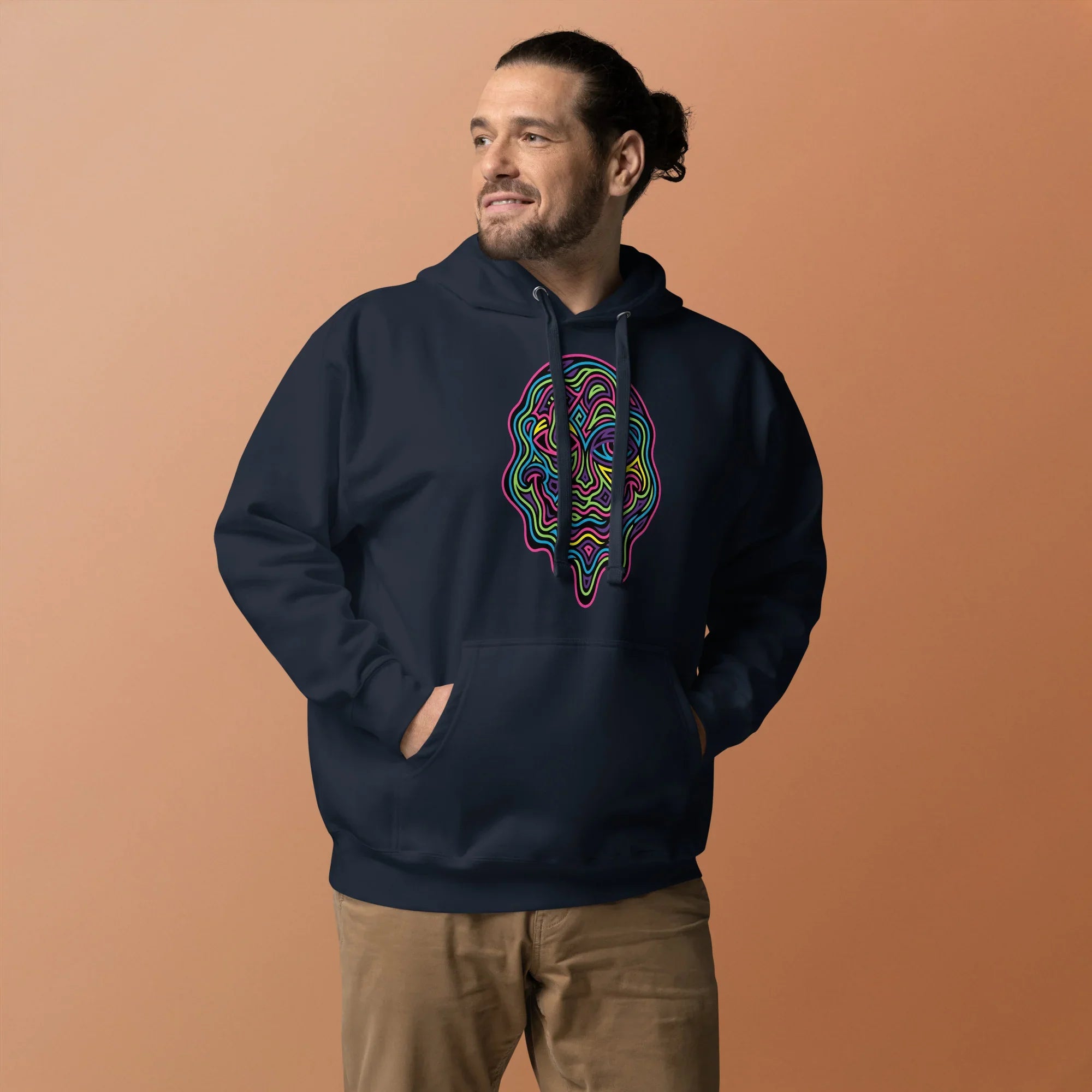 Man wearing navy premium pullover hoodie with colorful psychedelic face design, standing against beige background