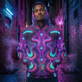 Man wearing Mad Lad Designs psychedelic neon hoodie in a vibrant urban alley at night