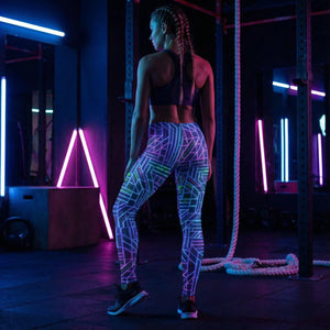 Woman in blacklight gym wearing neon geometric leggings and sports bra, psychedelic streetwear