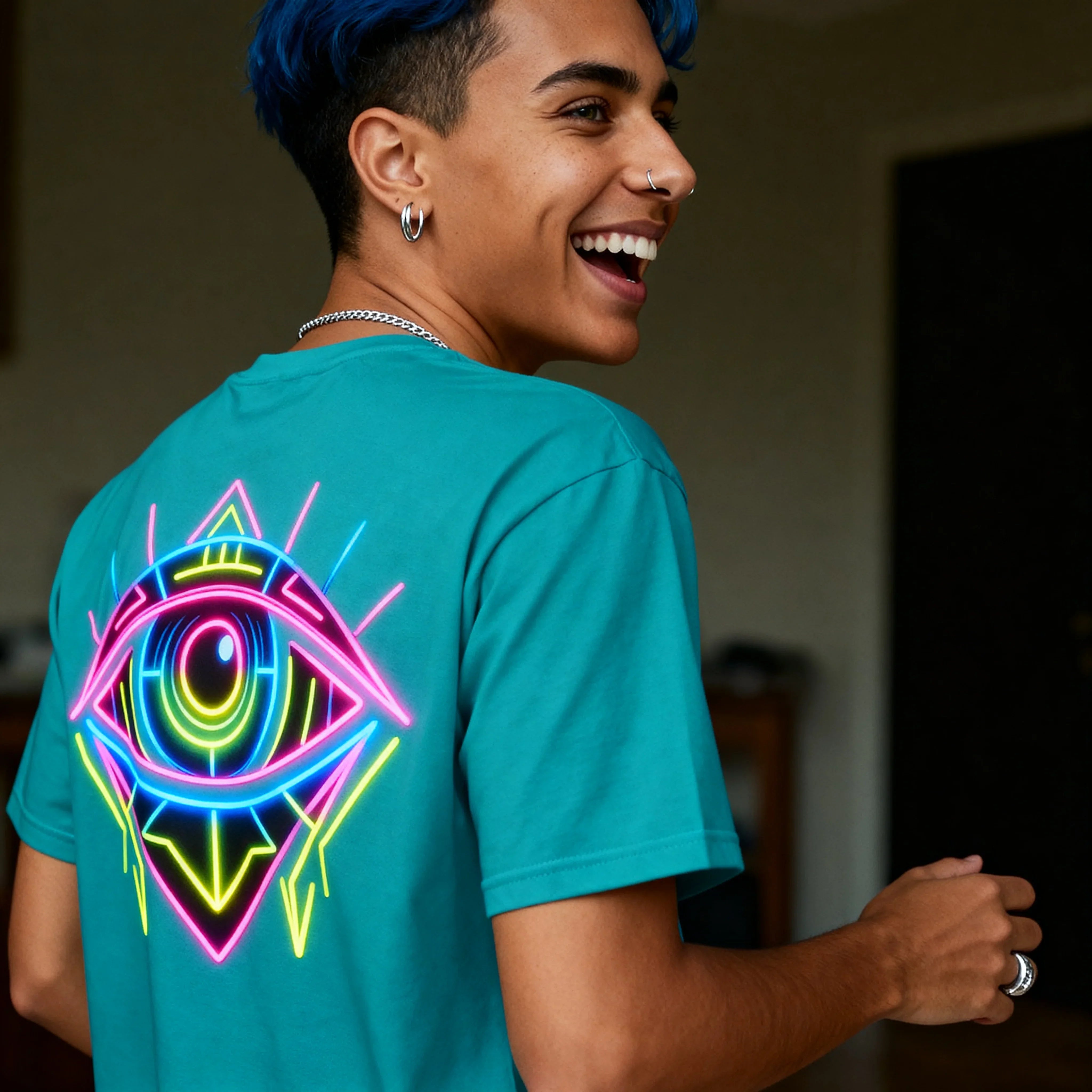 Smiling person in teal shirt with neon psychedelic eye design, vibrant streetwear fashion