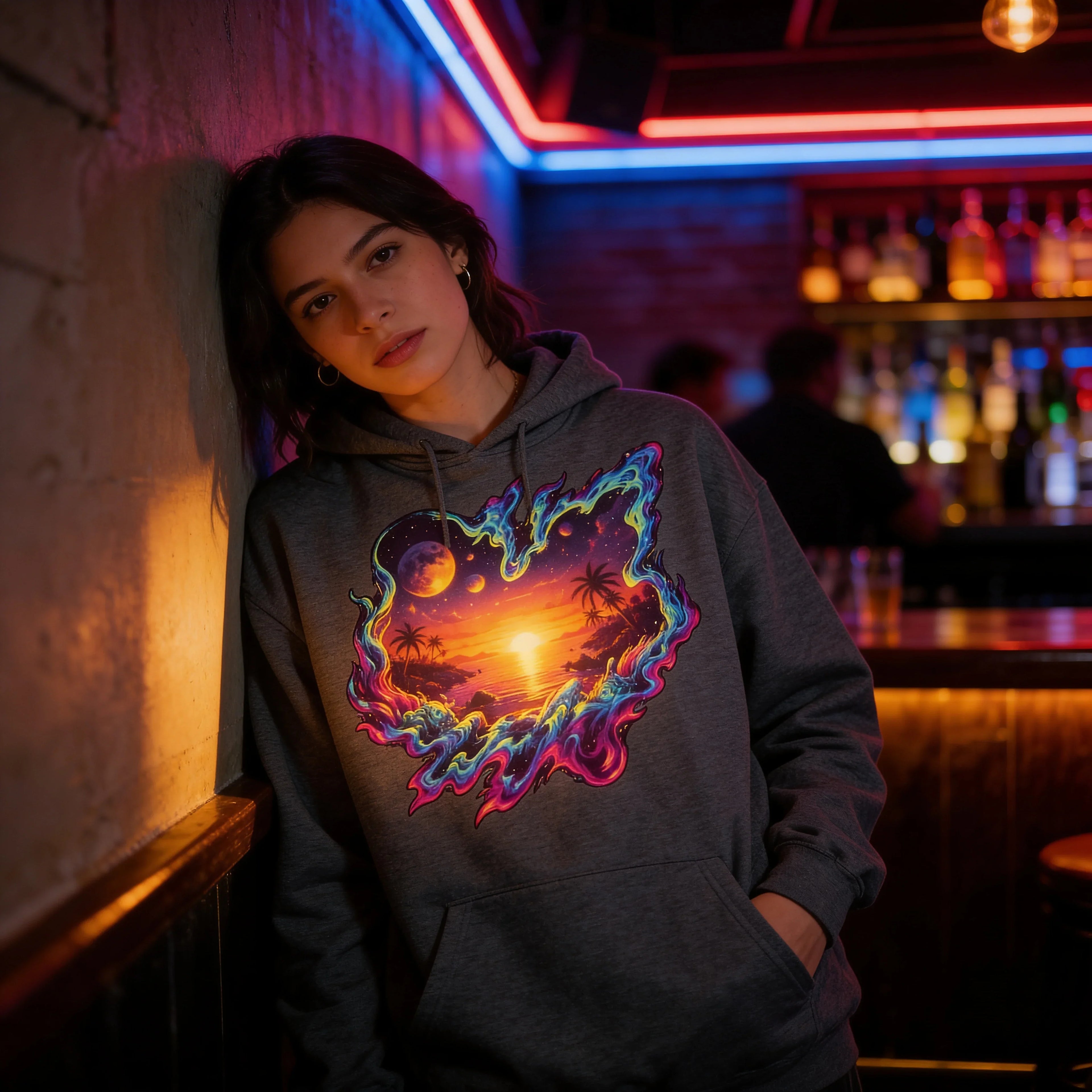 Woman modeling a gray hoodie with neon psychedelic sunset beach design, bar background