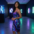 Woman in vibrant psychedelic dress at neon art gallery, Mad Lad Designs streetwear