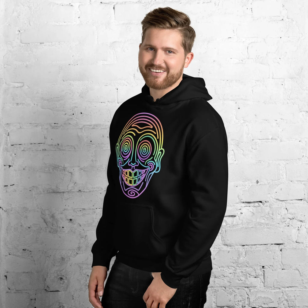 Man wearing black hoodie with neon psychedelic skull art by Mad Lad Designs, smiling by white brick wall
