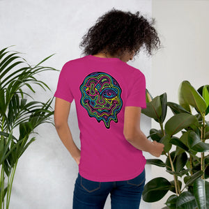 Woman wearing berry-colored unisex t-shirt with vibrant psychedelic neon abstract face design on back, green plants background