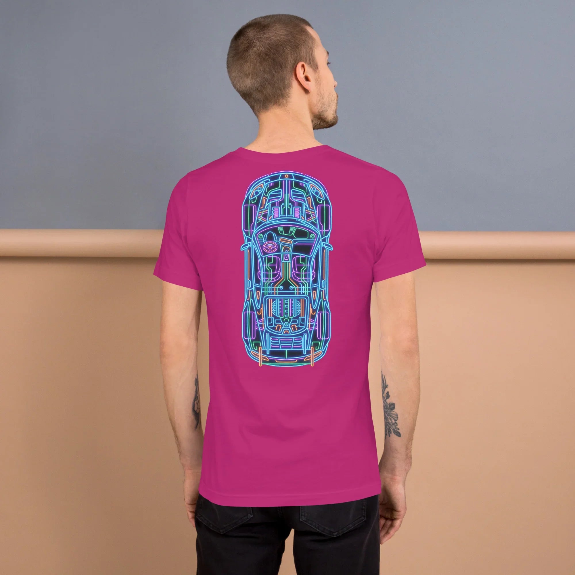 Man wearing berry unisex T-shirt with neon car blueprint design on back against two-tone background