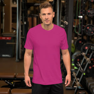 Man wearing unisex berry-colored staple t-shirt in gym setting with fitness equipment