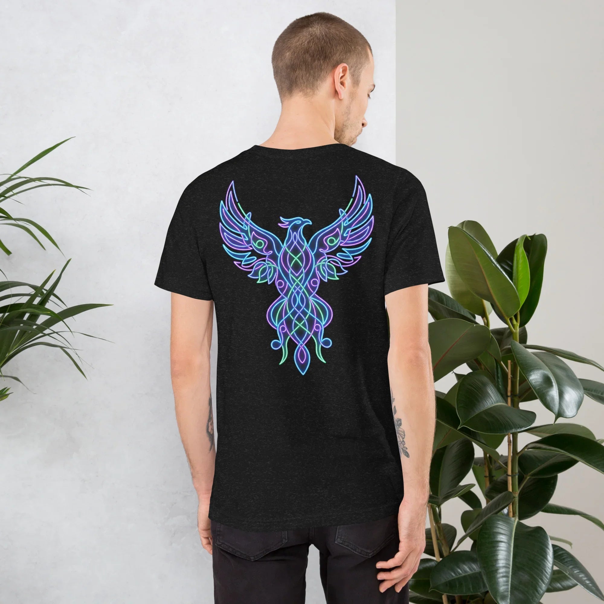 Man wearing black heather unisex staple t-shirt with vibrant neon psychedelic phoenix design on back