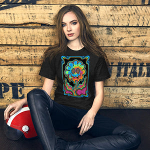 young woman wearing black psychedelic t-shirt with colorful swirling flower graphic, sitting by wood wall with red helmet