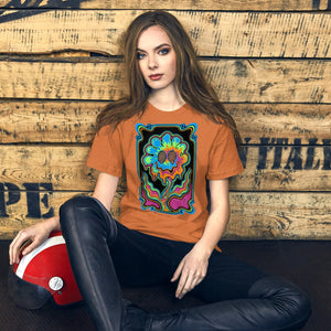 Young woman wearing heather autumn orange t-shirt with colorful psychedelic melting flower design, sitting by wooden wall, holding red motorcycle helmet