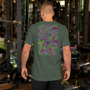Man in gym wearing heather forest green t-shirt with colorful psychedelic mushroom and face design on back