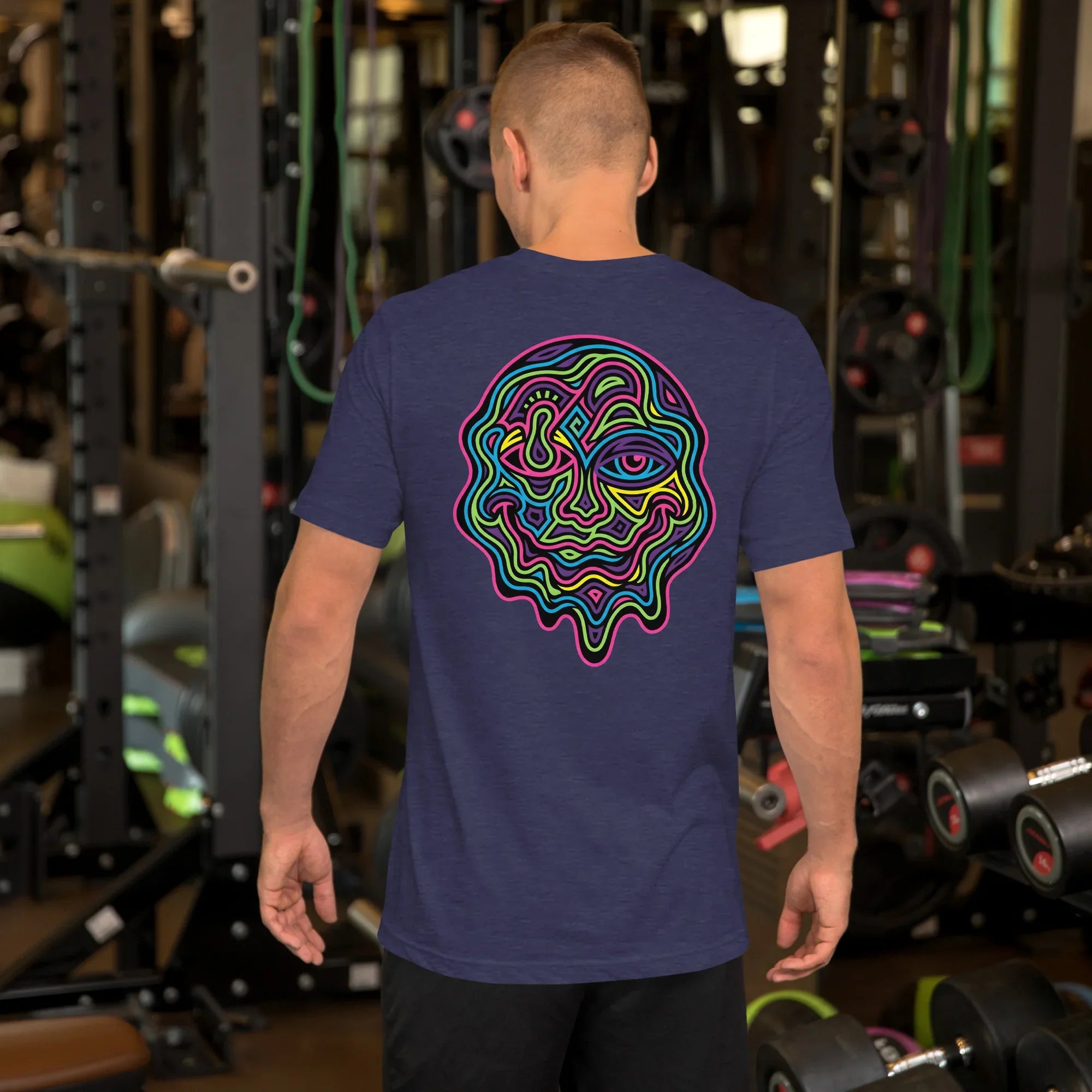 Man in gym wearing heather midnight navy unisex staple t-shirt with colorful psychedelic face art on back