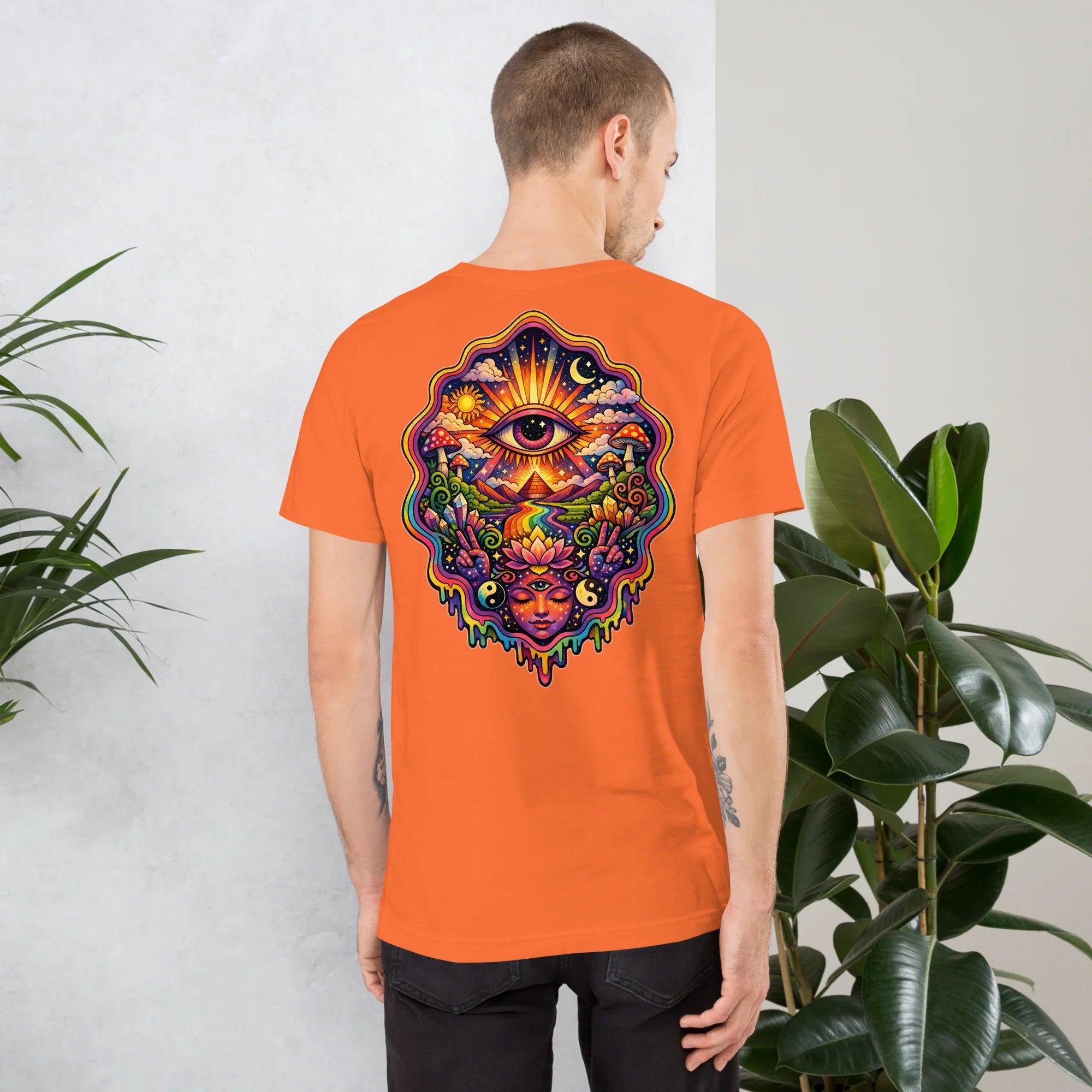 Man wearing bright orange unisex t-shirt with vibrant psychedelic eye and cosmic art design on back