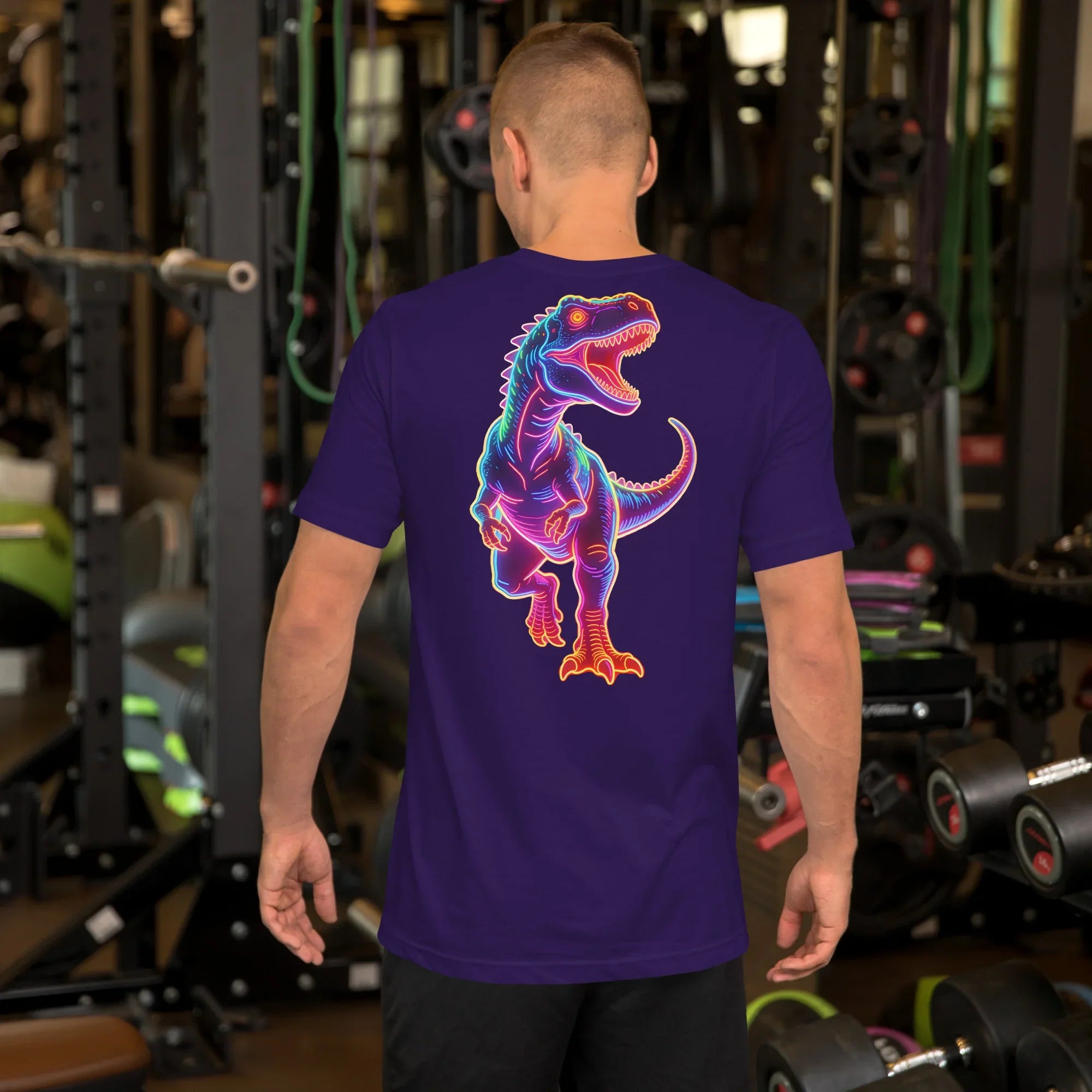 Man in gym wearing purple T-shirt with colorful roaring dinosaur graphic on back