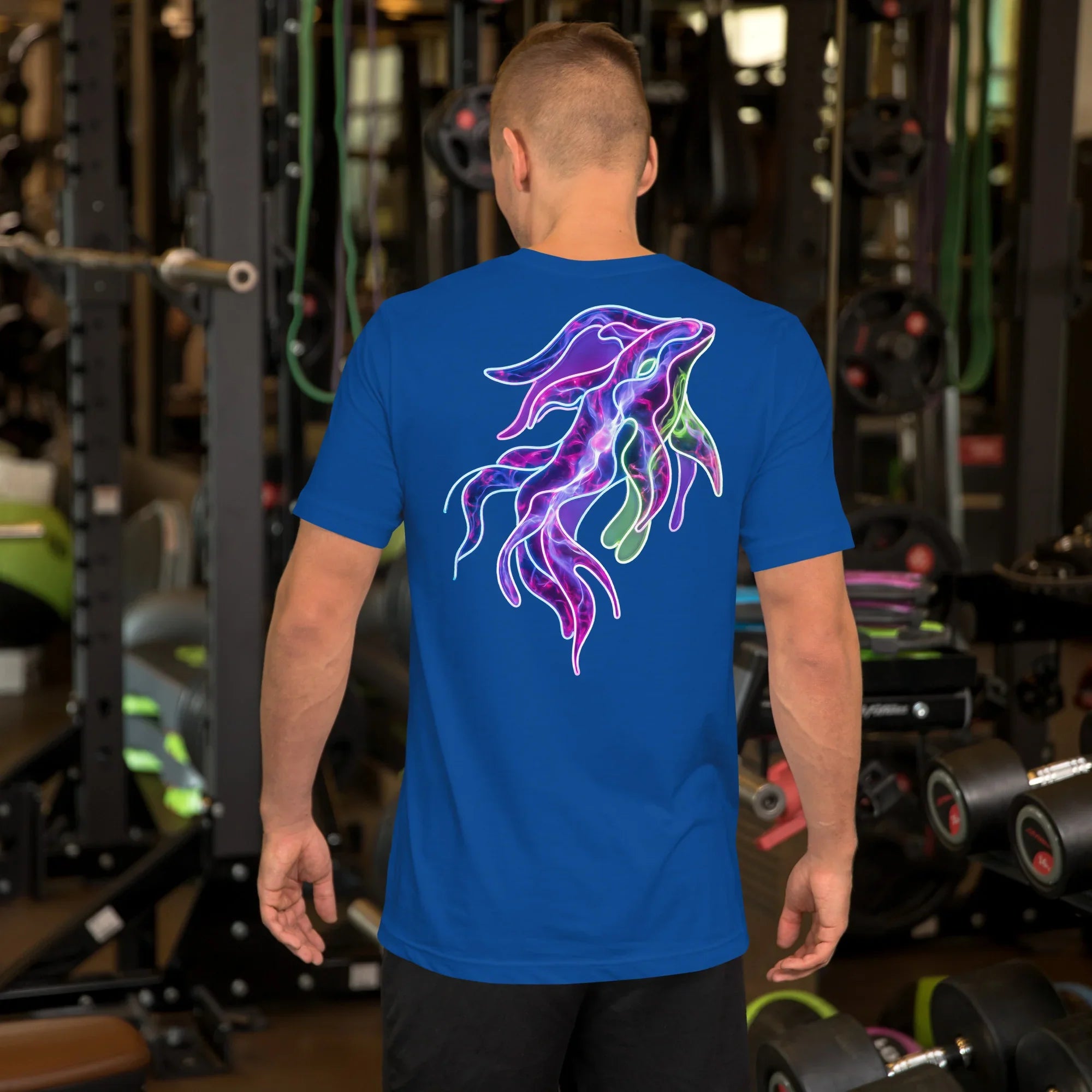 Man wearing true royal blue unisex T-shirt with bright neon psychedelic squid design on back in gym setting