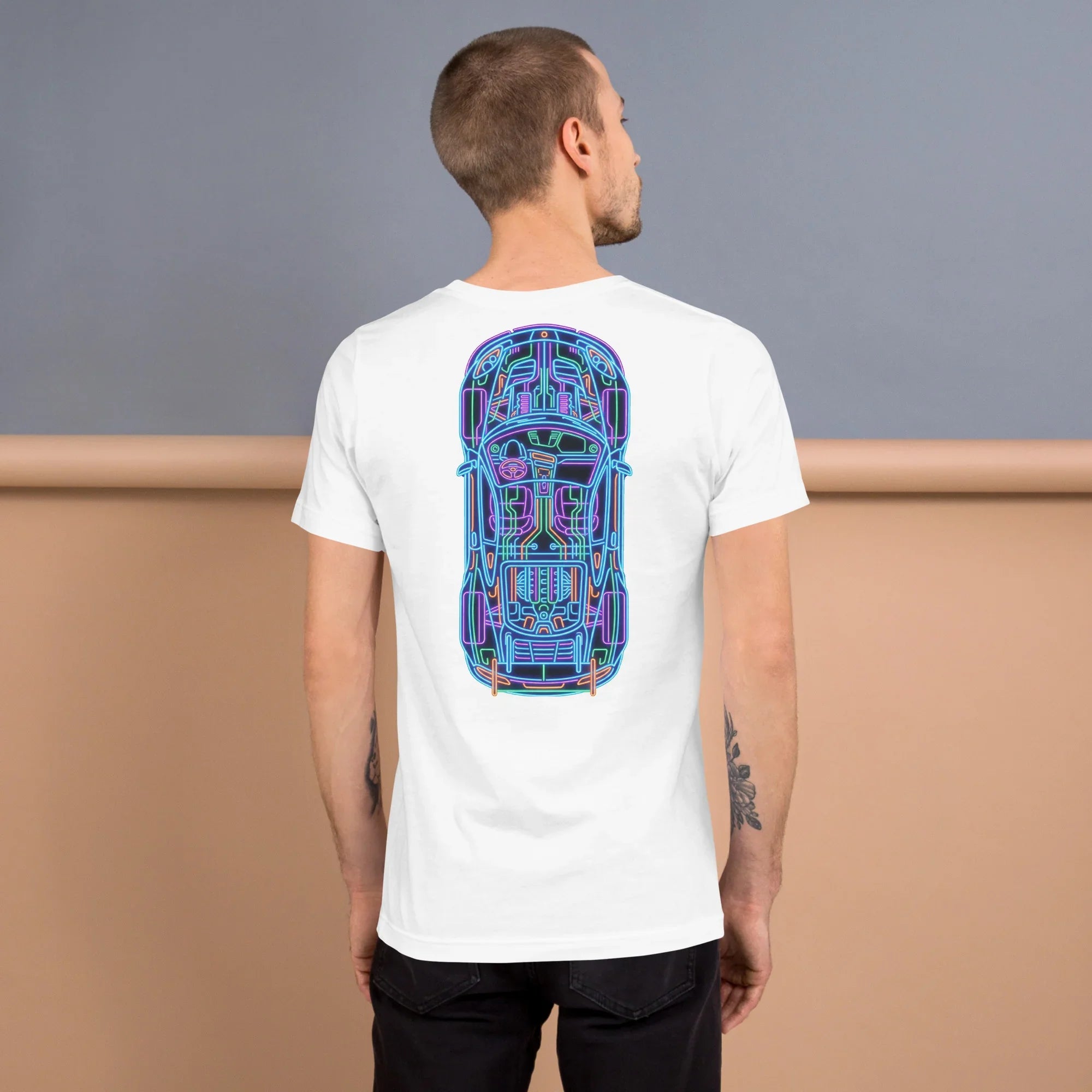 Male model wearing white unisex T-shirt with neon blueprint car design on back, studio background