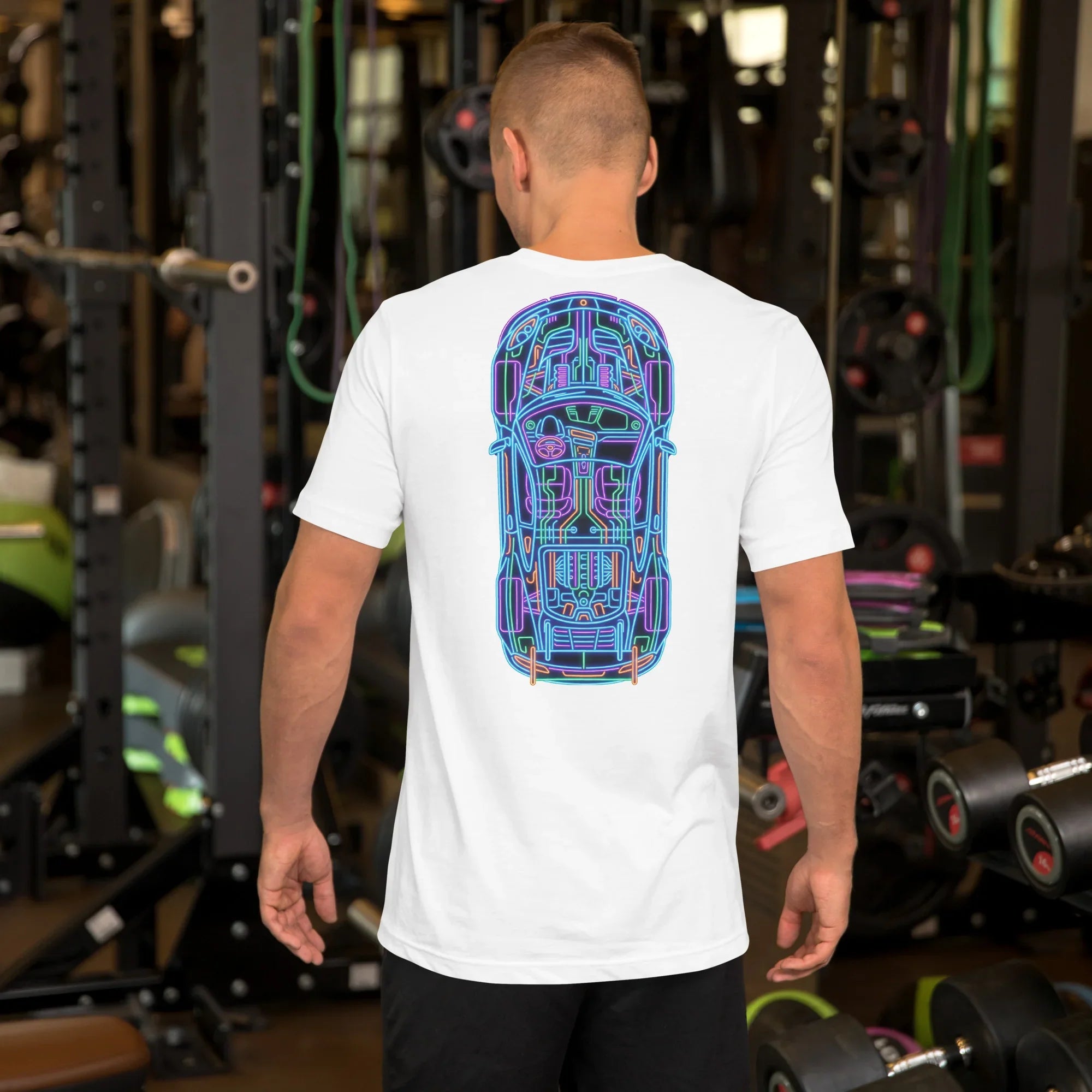 Man wearing white unisex t-shirt with colorful neon car blueprint graphic on back in gym setting