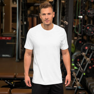 Man wearing a plain white unisex staple t-shirt in a gym setting with fitness equipment in background
